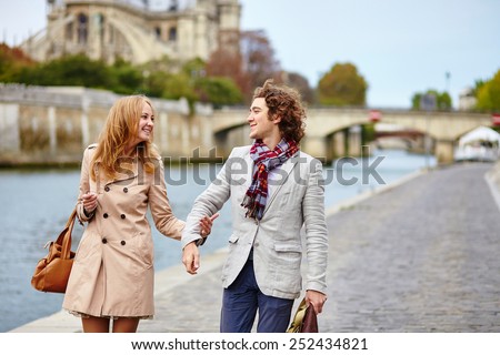 Young loving couple in Paris near Notre-Dame cathedral