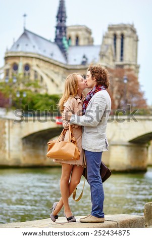 Young loving couple in Paris near Notre-Dame cathedral