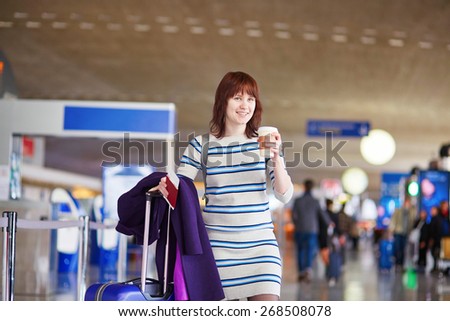Beautiful young female passenger at the airport with take away coffee
