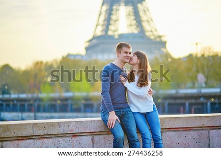 Young romantic couple in Paris having fun near the Eiffel tower