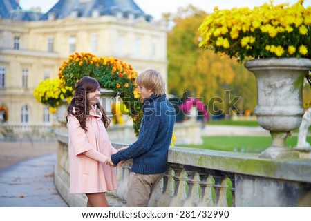 Young dating couple in the Luxembourg gardens of Paris on a bright fall day