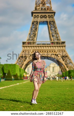 Beautiful young woman walking in Paris near the Eiffel tower on a nice spring or summer day