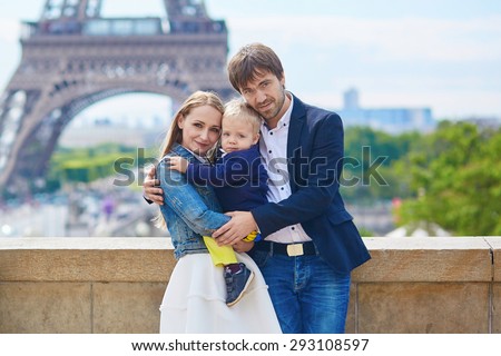 Happy family of three having fun together in Paris near the Eiffel tower