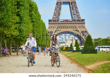 Romantic couple riding bicycles near the Eiffel tower in Paris