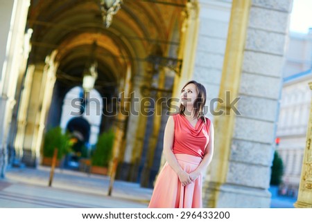 Beautiful young woman walking near the town hall (Rathaus) in Vienna, Austria