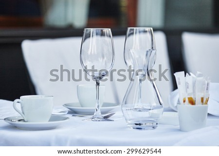 Empty wine glasses and coffee cup on the table of Parisian outdoor cafe