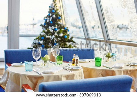 Decorated christmas dining table with wine glasses and christmas tree in background