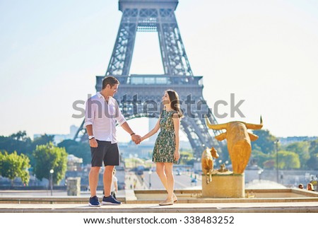 Young romantic couple in Paris near the Eiffel tower, enjoying their vacation to Paris