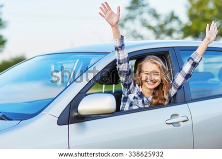 Happy young woman looking out of the car window