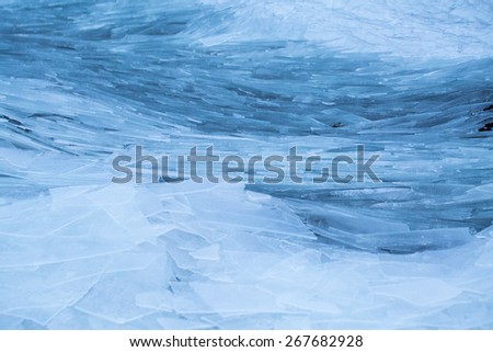Shards of ice washed up on lake shore like frozen waves, Lofoten, Norway