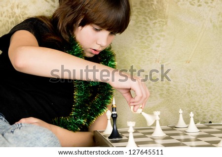small the girl was sitting on the sofa at and plays chess home