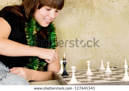 small the girl was sitting on the sofa at and plays chess home
