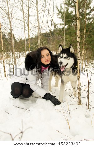 Girl and Siberian Husky in the woods in winter
