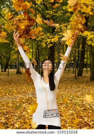 a girl throws leaves on the nature