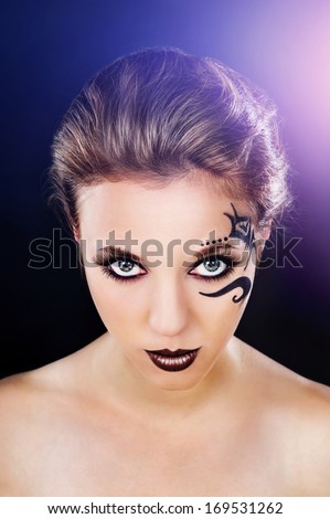 beautiful girl with a tattoo on his face on a black background