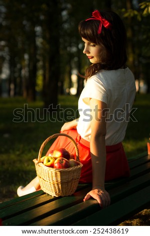 girl in a meadow under a tree sitting on the bench. On nature