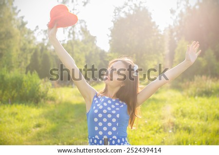 Beautiful girl holding high above his head heart. On nature