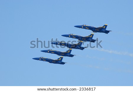 Five Blue Angels with yellow-helmeted pilots flying in tight diagonal formation. Fleet Week 2006, San Francisco.