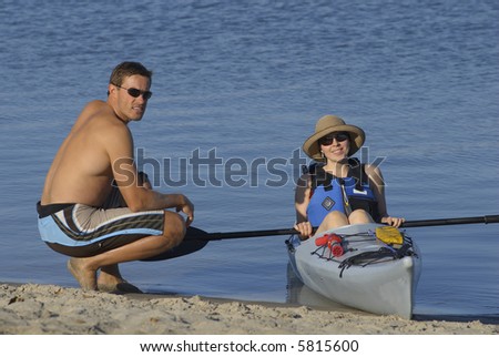 Attractive young female kayaker and her instructor on the beach at Mission Bay, San Diego, California.