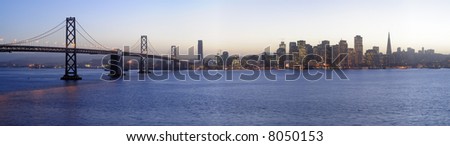 High-resolution panoramic image of Bay Bridge and San Francisco downtown decorated by Christmas lighting at dusk (shot from Treasure Island). Copyspace on