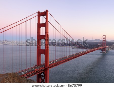 Delicate lilac, pink and purple hues play in the sky behind high-resolution stitched image of Golden Gate Bridge. Copyspace on top right.