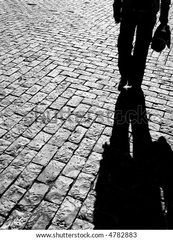 vision of a silhouette walking on a typical portuguese pavement creating a shadow