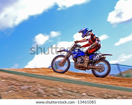 Motocross rider accelerates up the hill to make the jump.