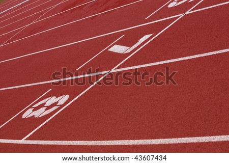 View of a red tartan athletic running track with white numbers.