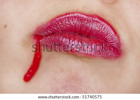 Close up view of some strawberry syrup on red lips.