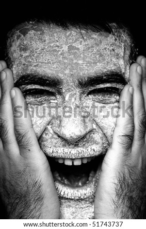 Close up view of a man\'s hands on the face covered in flour, screaming.