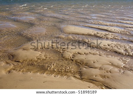 View of natural pools made by the tide on the sand.