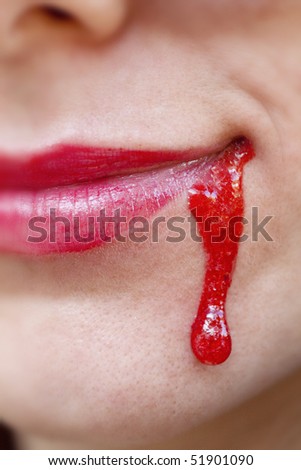 Close up view of some strawberry syrup on red lips.
