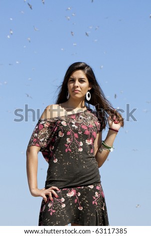 Beautiful girl with floral dress posing on a forest with lots of birds.