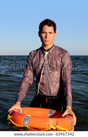 Business man holds a lifesaver buoy on the water.