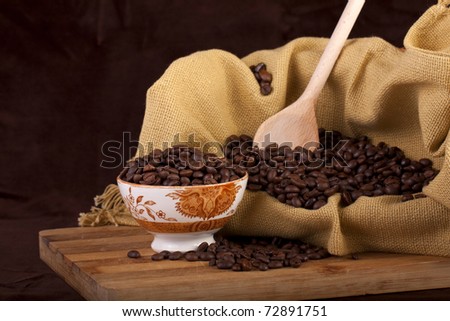 Close view of a bunch of roasted beans of coffee inside a bowl.