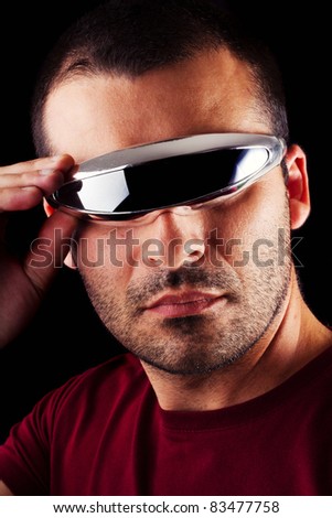 Close detail view of a young male man with futurist glasses isolated on a black background.