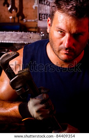 View of a garage mechanic man holding an adjustable spanner.