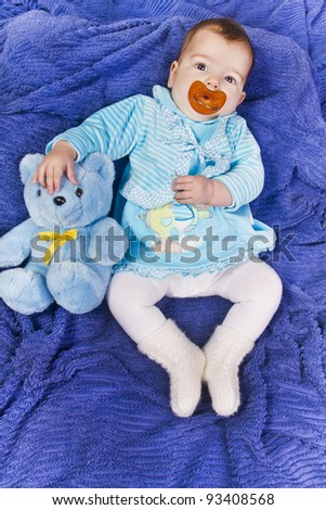 View of a newborn baby with a stuffed toy.