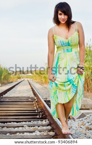 View of a beautiful girl with a spring dress on a railway.