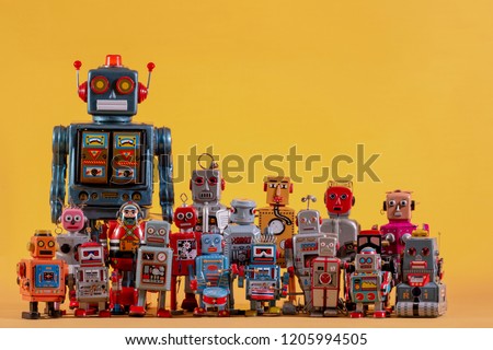 Vintage tin robot toys isolated on a yellow background.