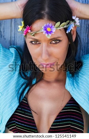 View of a beautiful woman in bikini in the beach, bathed by the sunny rays of Summer next to a blue wood house.