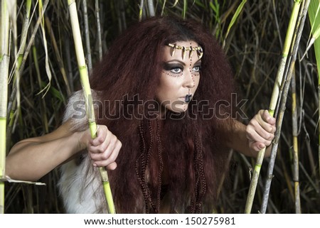View of a beautiful young strong hunter warrior woman searching on nature.