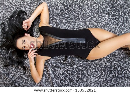 View of a beautiful young woman posing on top of a cool carpet.