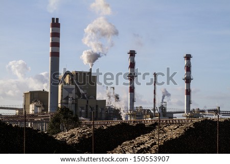 View of a industrial paper factory with tall fume towers.