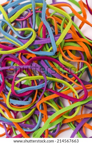 Close up view of a unordered pile of colorful elastic rubber bands isolated on a white background.
