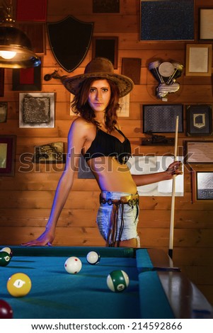 Close view of a beautiful cowgirl on a snooker club.