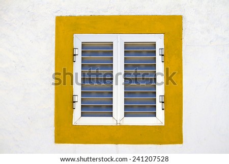 Close up view of a modern aluminum window with a yellow frame.