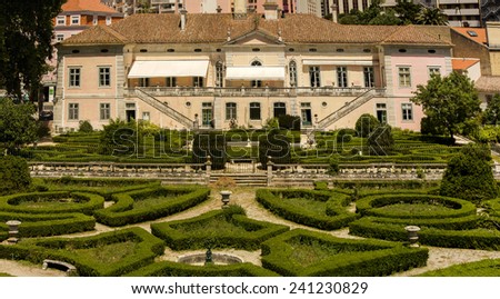 View of a beautiful classical building with a wonderful trimmed bush garden located on the Lisbon zoo, Portugal.