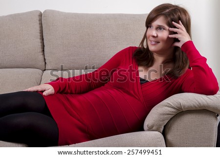 Close up view of a expecting pregnant happy woman on the comfort of her home.
