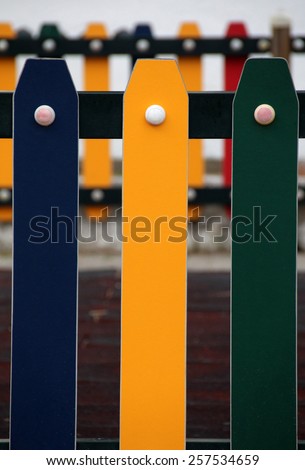 Close view of colorful painted playground fence.